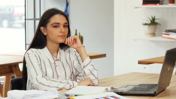 Young Businesswoman Looking Thoughtfully To the Camera