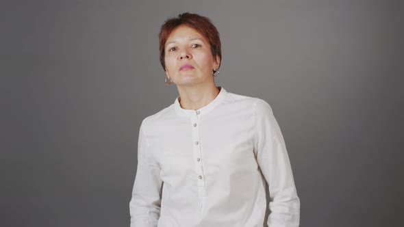 Portrait of Serious Adult Woman on Grey Studio Background