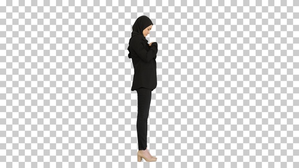 Business woman in hijab standing fixing her hijab, Alpha Channel