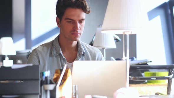 Creative young Man Working in Office, Typing On Laptop