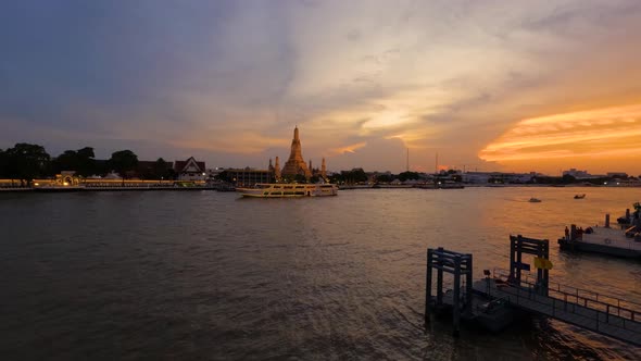 Colorful Sunset time-lapse at Chao Phraya River riverside with cruise boats traveling by Wat Arun Te