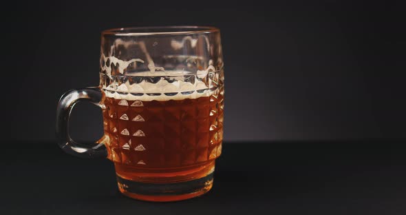 Pouring Beer Into Glass Over Dark Background