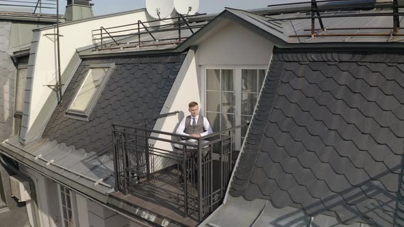 Man Groom Businessman Is Drinking Coffee From a White Cup on the Balcony at Home in Wedding Morning