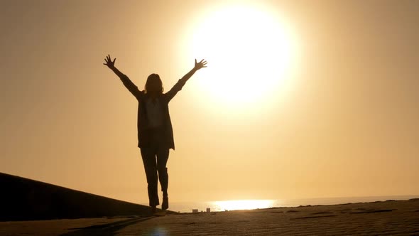 Woman in Business Attire Raising Her Arms Embracing Freedom During Sunset