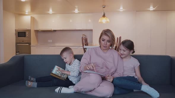 Female Look on Daughter Draw While Her Son Playing with Book