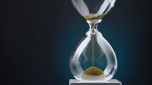 An Hourglass Made of Yellow Metal Shavings Passes Through a Funnel Symbolizing the Concept of Time