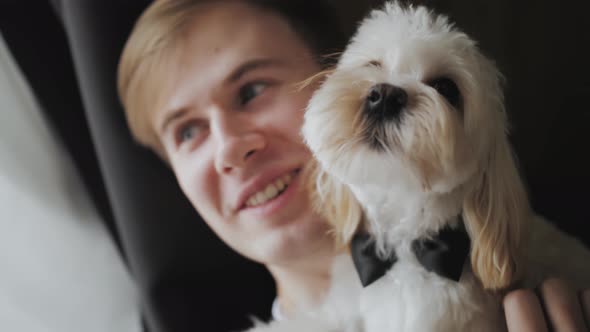 Young Man Holding a Dog in His Arms Closeup