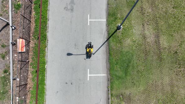 A top down view of a recumbent cyclist, riding in a park on a sunny day. The camera tilted down, dol