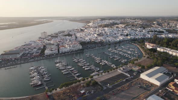 Marina in Ayamonte, Spain. Aerial pull out during sunset with historical buildings in background