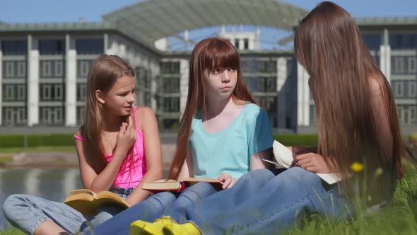 Group of Diverse Teen School Children Reading Books in Park