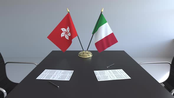 Flags of Hong Kong and Italy and Papers on the Table