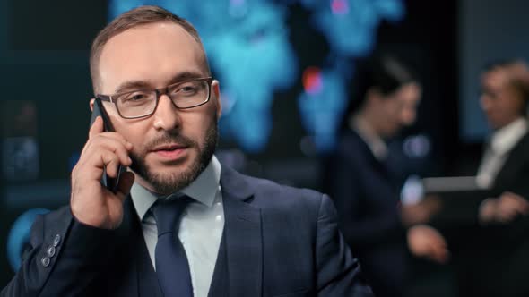 Handsome Male Entrepreneur Calling Mobile at Stock Exchange