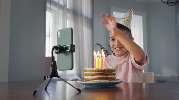 Boy Sitting In Front Of Cake At The Table