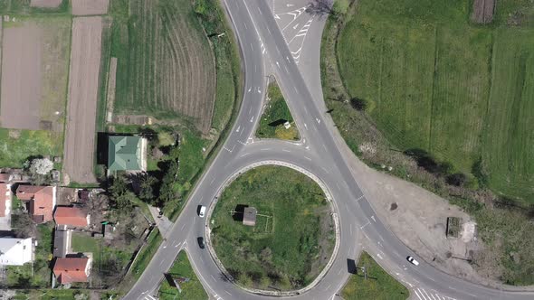 Roundabout traffic of cars and trucks on the circle ring road aerial top view.