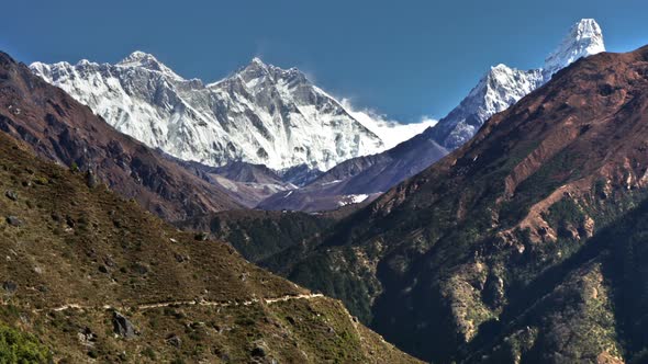 Time-lapse of Everest and surrounding peaks and people on a foreground trail.