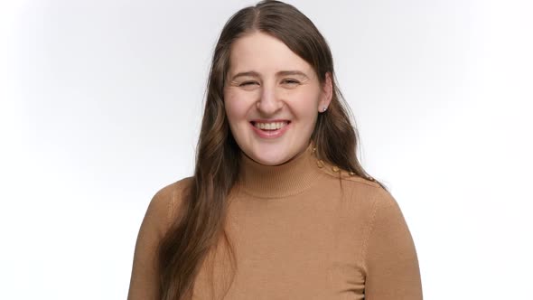 Studio Portrait of Happy Smiling Woman Aiming in Camera with Fingers