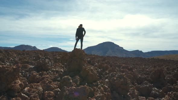 Tourist Man Walk Through the Mountains of Solidified Lava in the Teide Volcano National Park on the