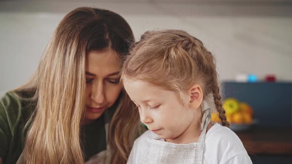 Mother and Little Girl with Long Hair are in Kitchen