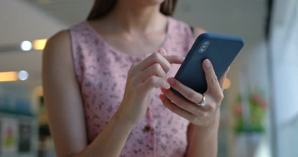 Woman use mobile phone inside shopping center