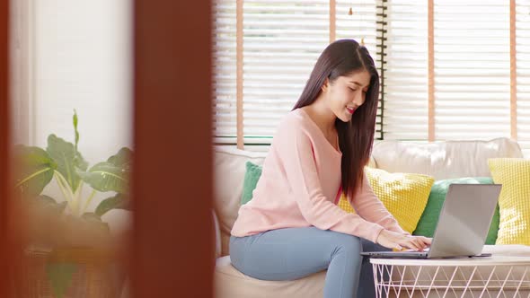 business asian young woman wear Pink Sweater work online with laptop