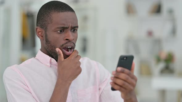 Portrait of African Man Reading To Loss on Smartphone, Failure 