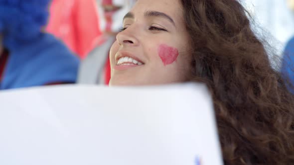 Loyal Caucasian Female Fan Cheering with Poster at Stadium