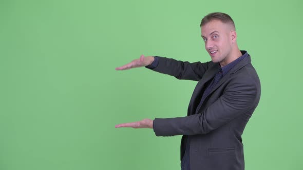 Happy Handsome Businessman in Suit Snapping Fingers and Showing Something