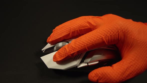 Person in Gloves Uses Wireless Mouse on Black Background