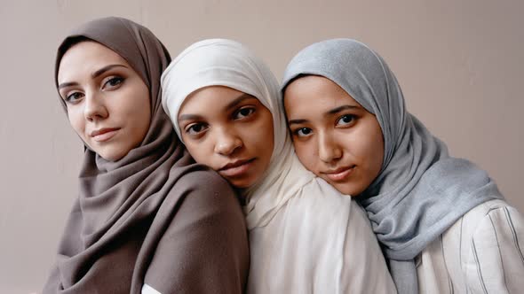 Three Muslim Girls Putting Heads on Each Other's Shoulder and Smiling at Camera