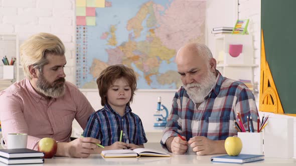 Father, Grandfather and Son After School Teaching. Schoolkid or Preschooler Learn with Parents