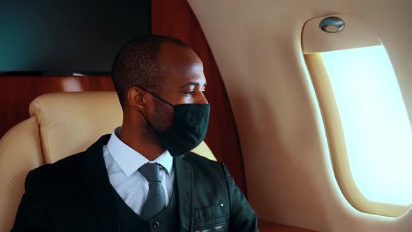 Businessman wearing protective face mask on airplane