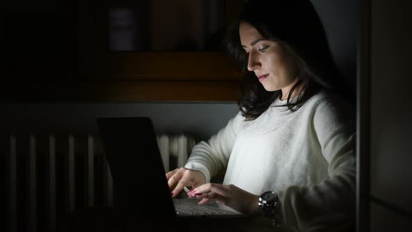 Young beautiful woman using computer sitting on a armchair