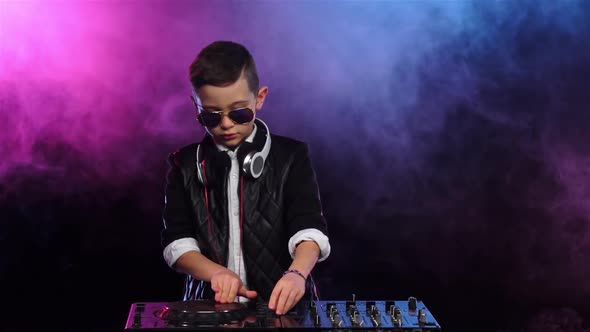 Boy in Glasses Playing on Vinyl. Smoky Background, Slow Motion