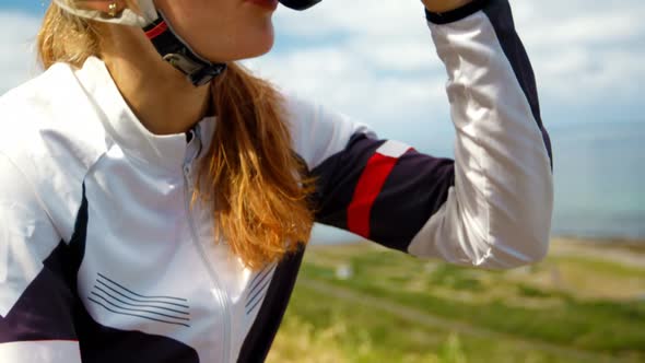 Female cyclist drinking Water on a countryside road 4k