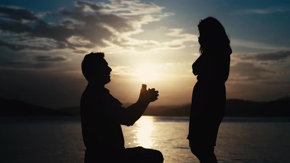 The Guy Makes a Proposal to the Girl to Get Married By the Sea at Sunset