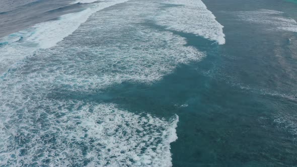 Aerial View of Beautiful Foamy Blue Sea Waves Splashing Towards the Beach