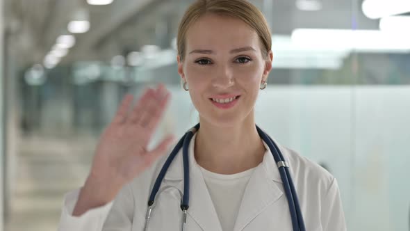 Portrait of Cheerful Female Doctor Waving at the Camera 