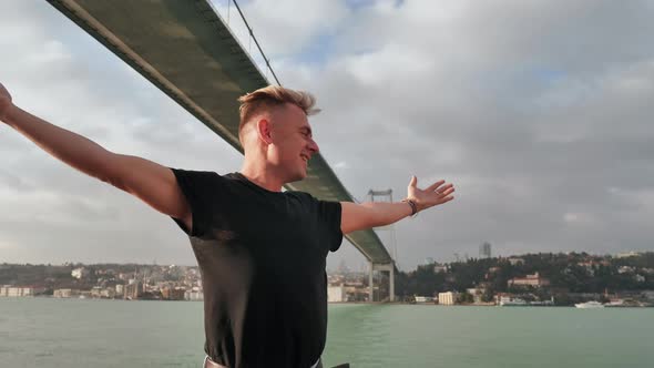 A Young Man Admires the Huge Bridge Over the Bosphorus in Istanbul