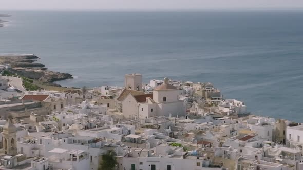 Aerial rotating footage of a church with the sea in the background in Polignano a Mare, Italy.