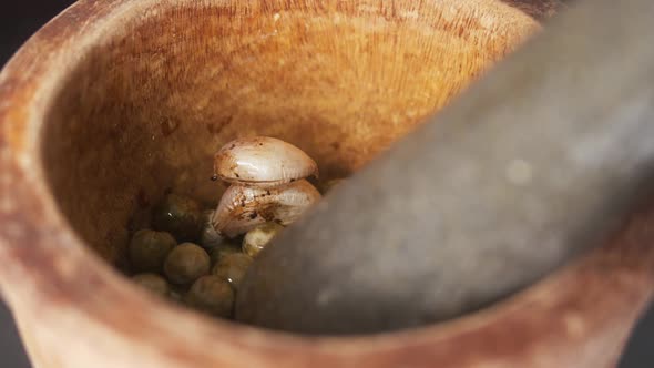 Filling a Mortar and Pestle with Chilies, Garlic and Green Peppercorns