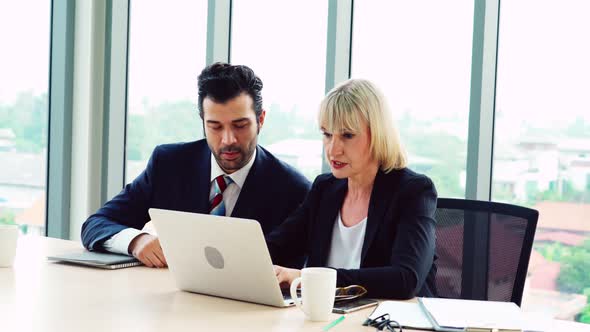 Two Business People Talk Project Strategy at Office