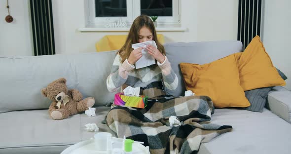 Girl with Scarf Around Neck Blowing Running Nose Into Napkin