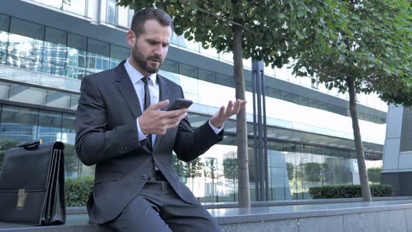 Beard Businessman Upset for Loss While Using Smartphone