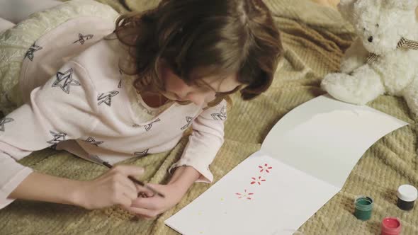 Little Girl Drawing Colorful Flowers in Her Album, Dreaming of Summer and Warmth