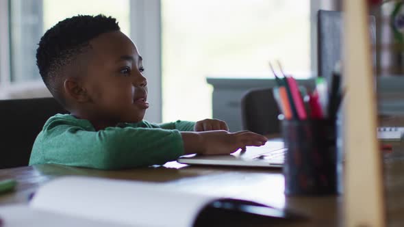 African american boy having a video call on laptop at home