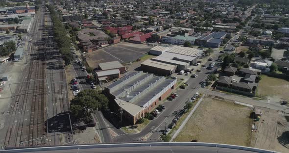 Aerial decent and arrive toward factory workshop and tracking over head of delivery truck below.