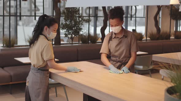 Women Cleaning Cafe Table Smiling