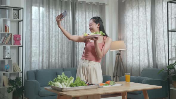 Smiling Asian Woman Holding A Dish Of Healthy Food And Taking Selfie With Smartphone