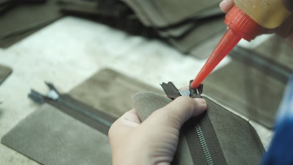 Close-Up Of Tailor Working On gluing and triming in leather work factory background