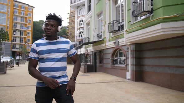 Cheerful Guy Enjoying Afrohouse Music on Street